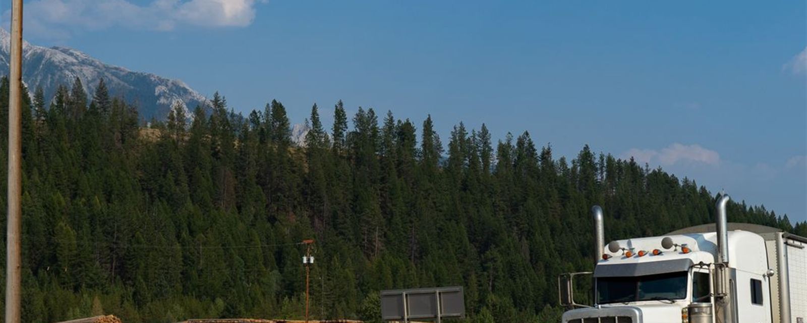 Trucks rolling through open mountain highway landscape